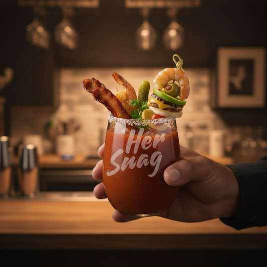 Her Snag" 20.5oz etched stemless wine glass featuring a weighted bottom, styled as a Bloody Mary with a tajin rim and garnishes.