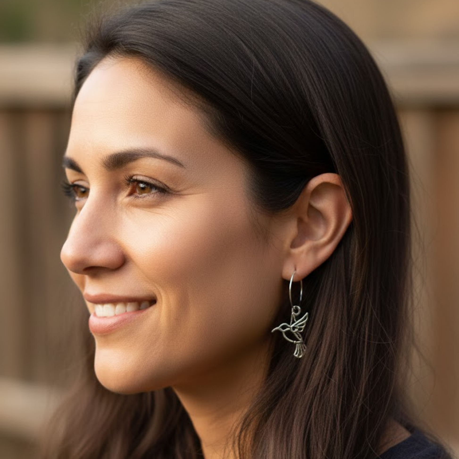 Lifestyle view of the signature hummingbird hoop earring by Expressive DeZien, included as a bonus in the Her Snag wine glass set.